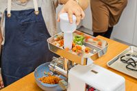 Person pushing veggies in STX International Turboforce Classic 3000 Series Electric Meat Grinder & Sausage Stuffer