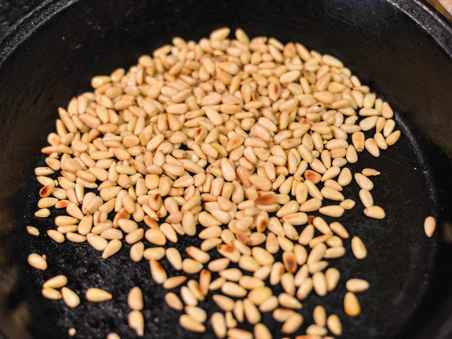Toasting pine nuts in a cast iron skillet. 