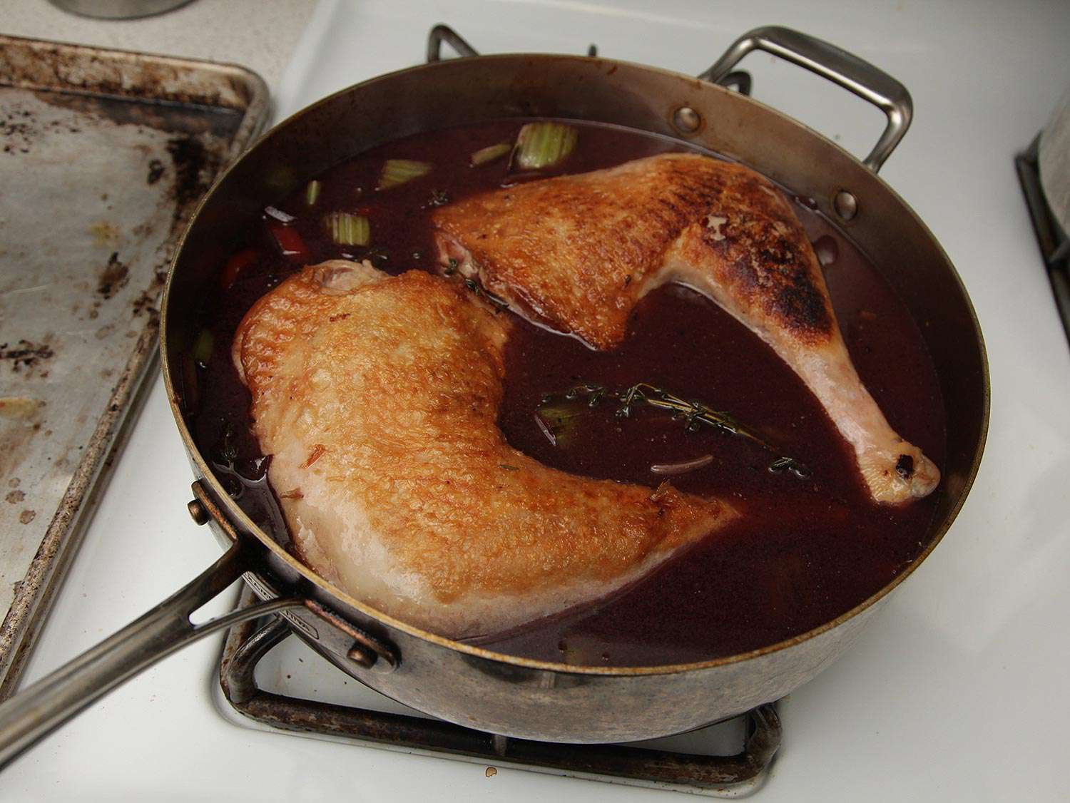 Adding turkey legs to the braising liquid. 