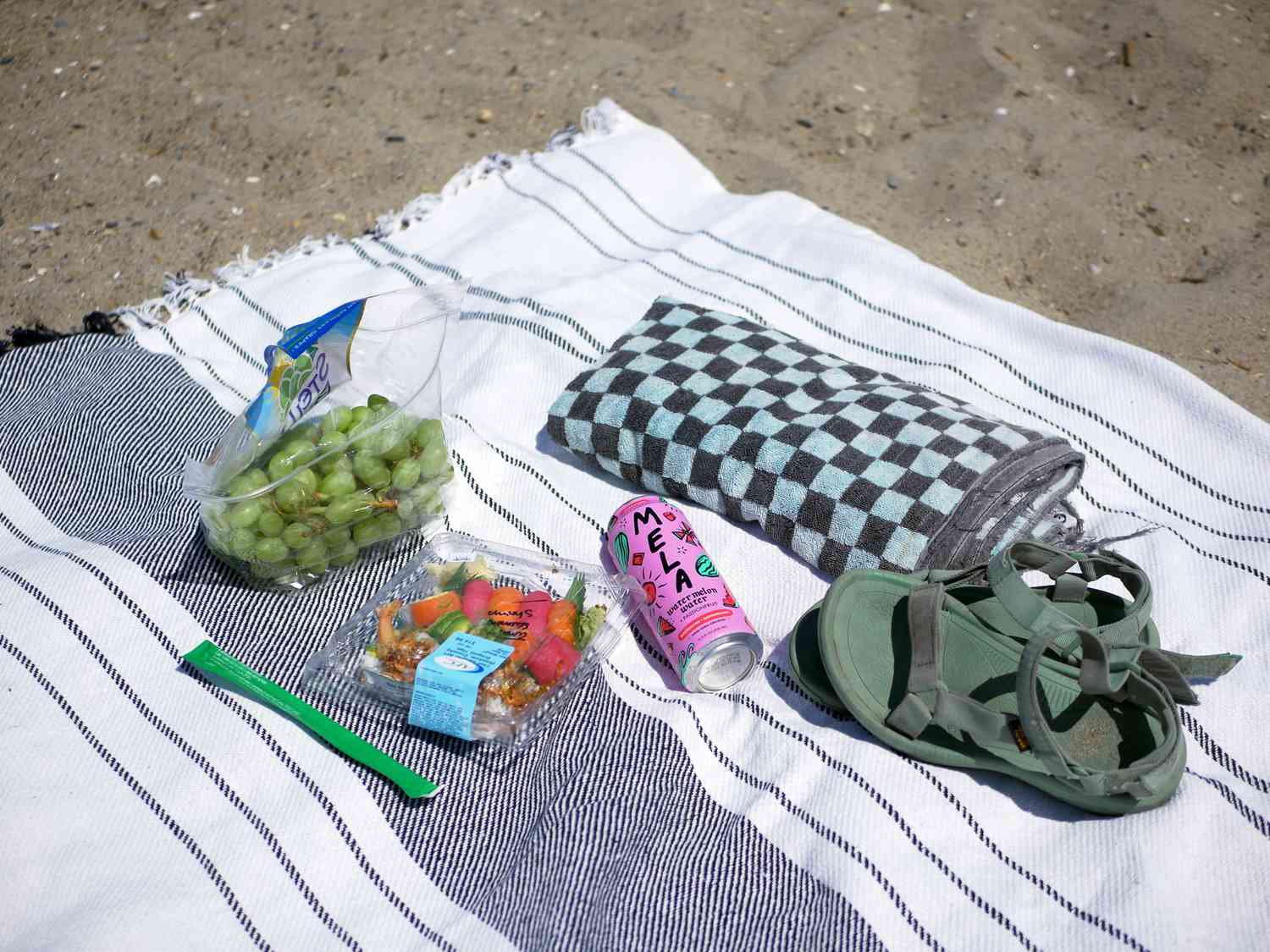 a closeup of sushi picnic lunch on picnic time blanket on sand