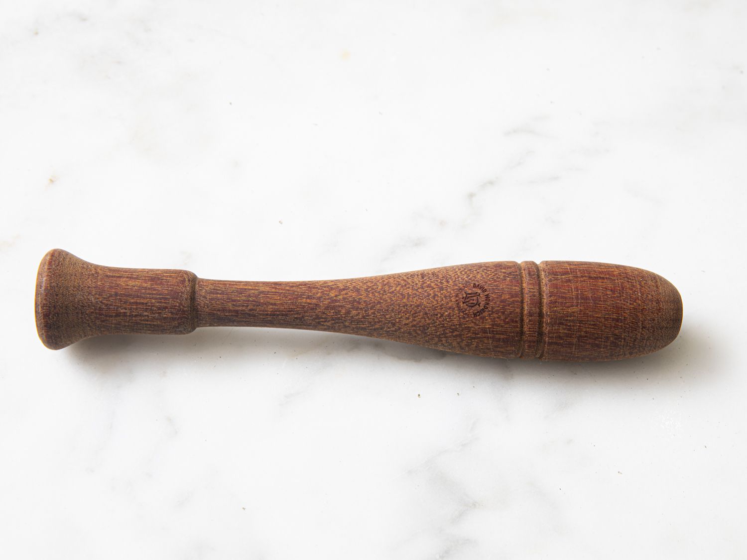 The wooden Cato muddler on a marble surface