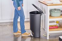 A person lifts the lid on the simplehuman Semi-Round Step Trash Can by stepping on the foot pedal