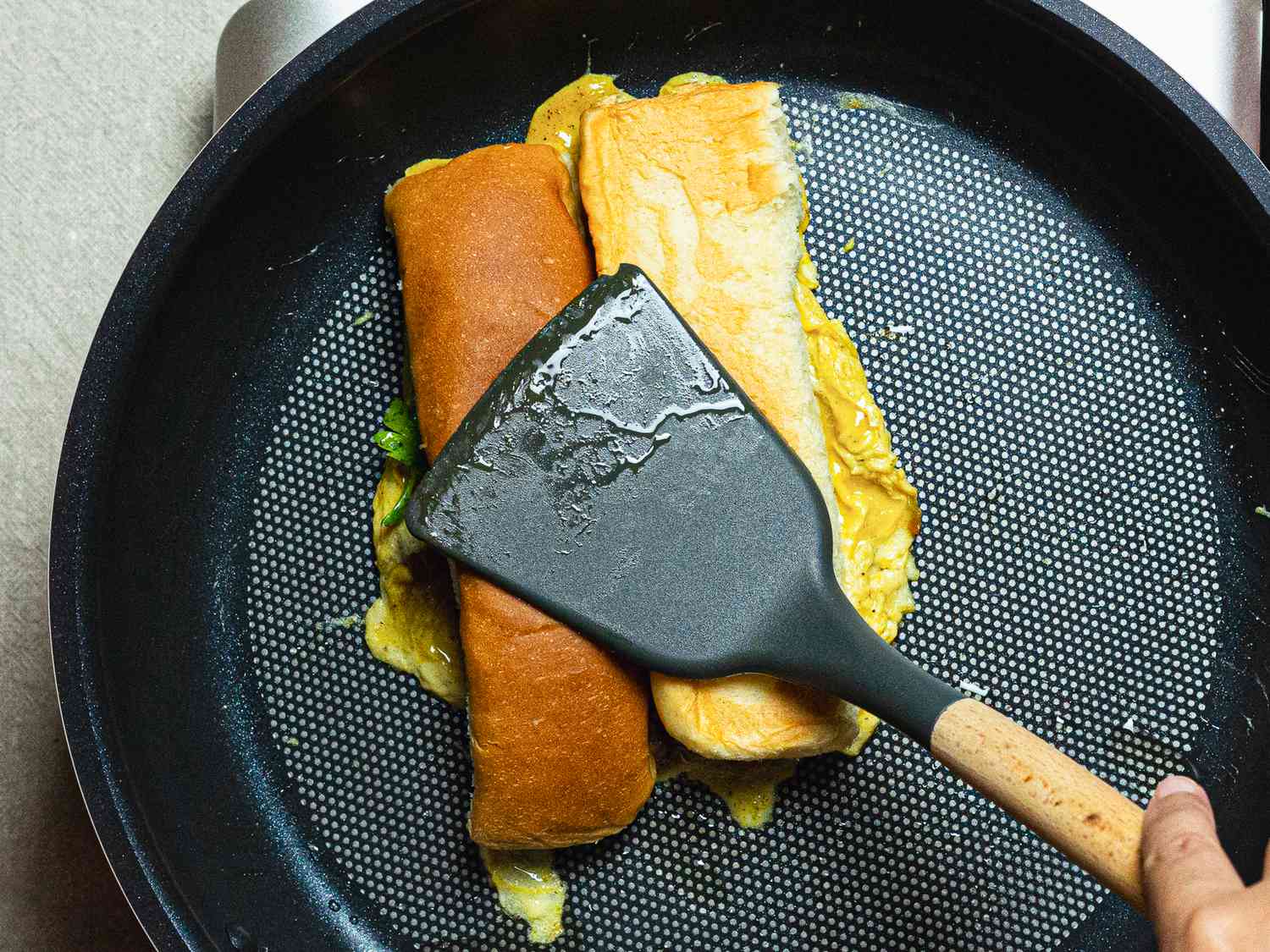 Overhead view of placing bun on eggs