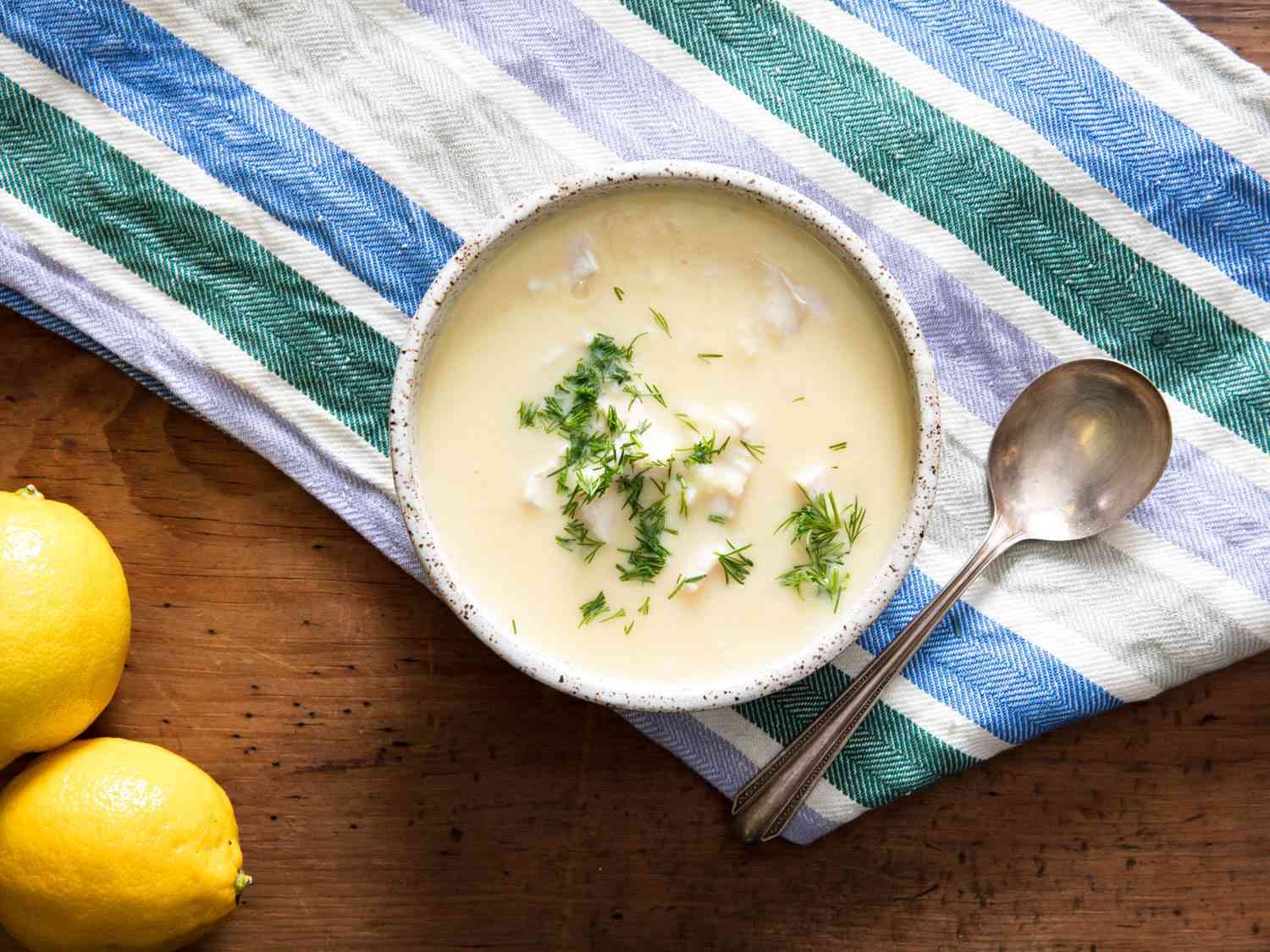 Top down view of a bowl of avgolemeno chicken soup on the table. 