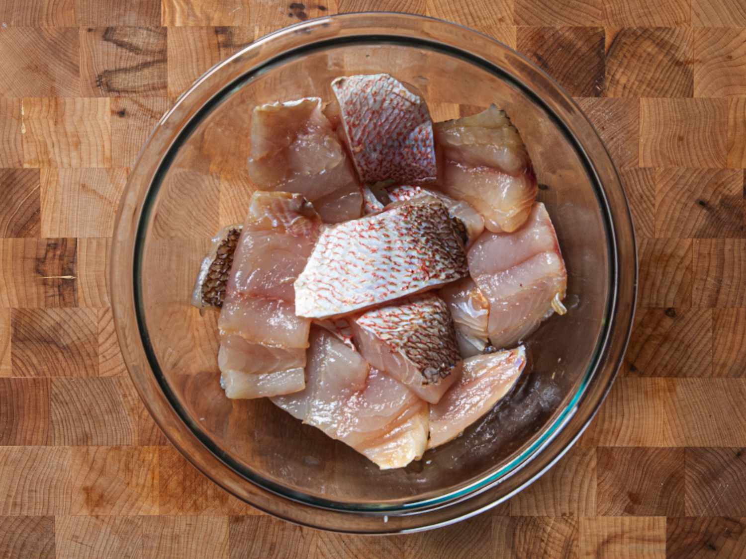 Overhead view of fish parts marinating in a bowl
