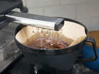 the brew head dispensing water into a basket with coffee grounds