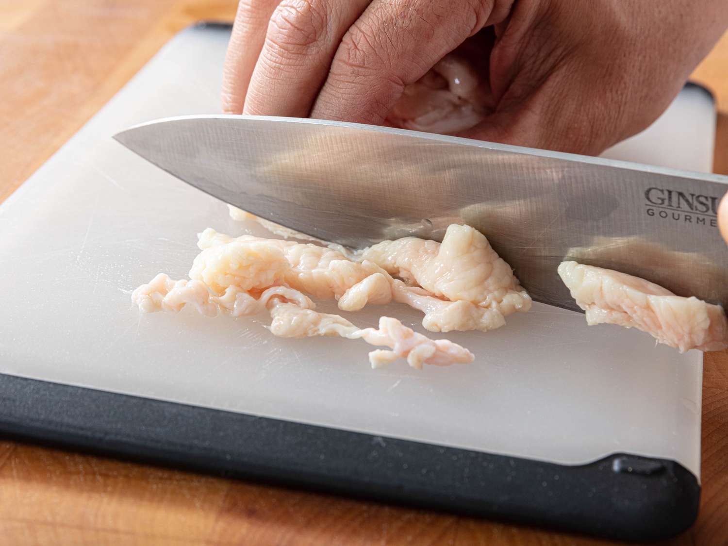 Slicing raw chicken skin