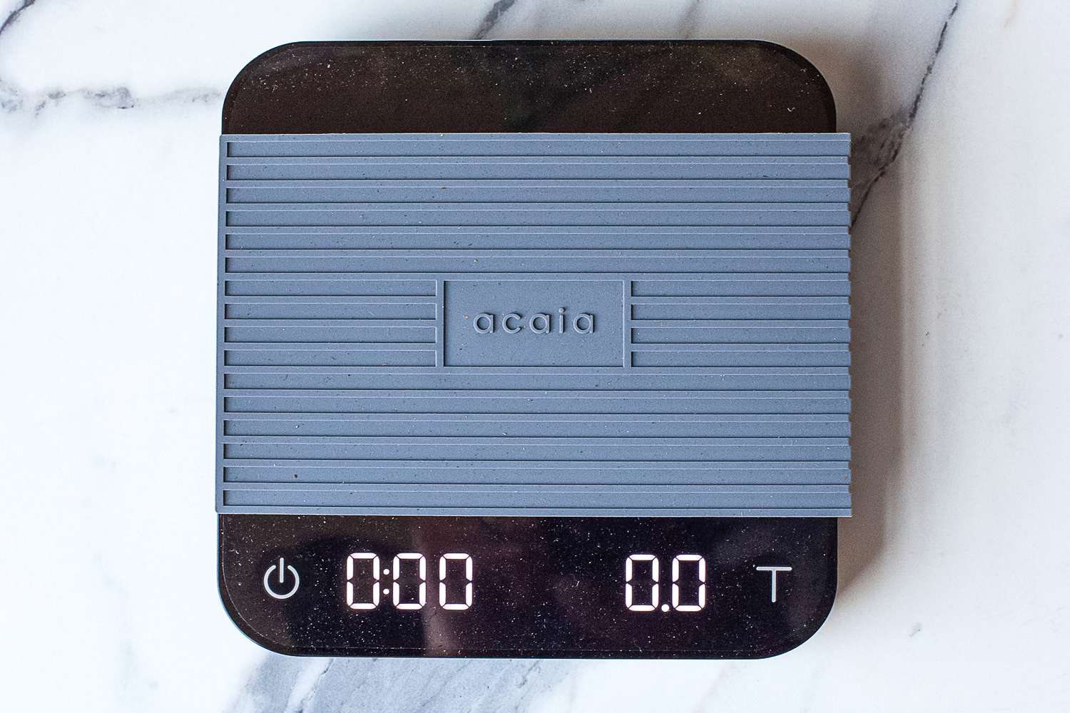 Acaia Pearl coffee scale with a protective cover and display showing zero readings