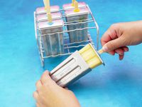 a person removing a popsicle from the onyx molds