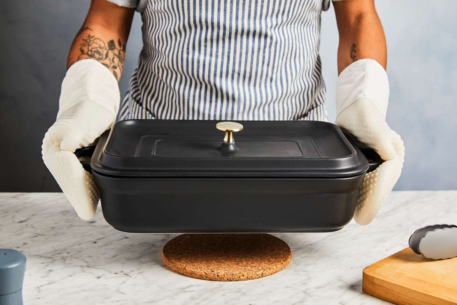 using oven mitts to grip and lift a casserole dish