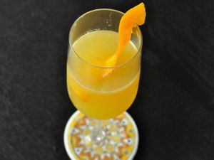 A Cara-Carry Me Away cocktail, served in a stemware glass with an orange twist.
