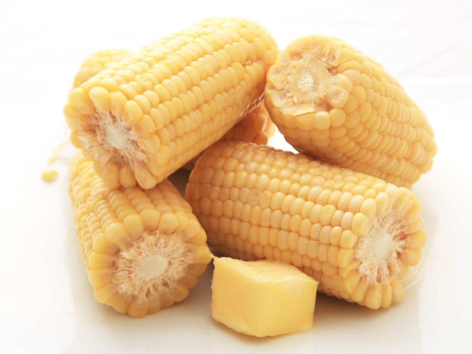 Pile of sous vide-cooked corn on the cob with extra butter on the side.