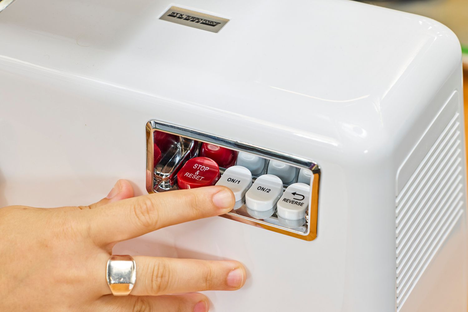 Person pressing buttons of STX International Turboforce Classic 3000 Series Electric Meat Grinder & Sausage Stuffer