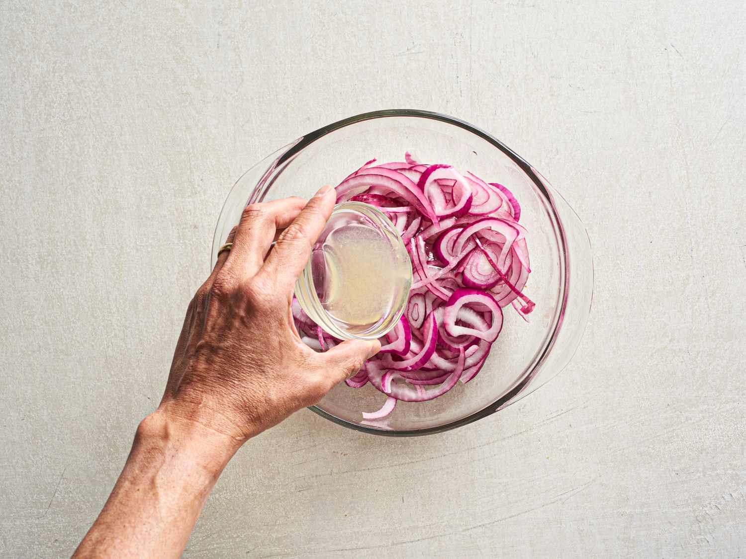 Pickling red onions in a bowl.