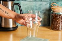 A person picking up the Kruve coffee cup.