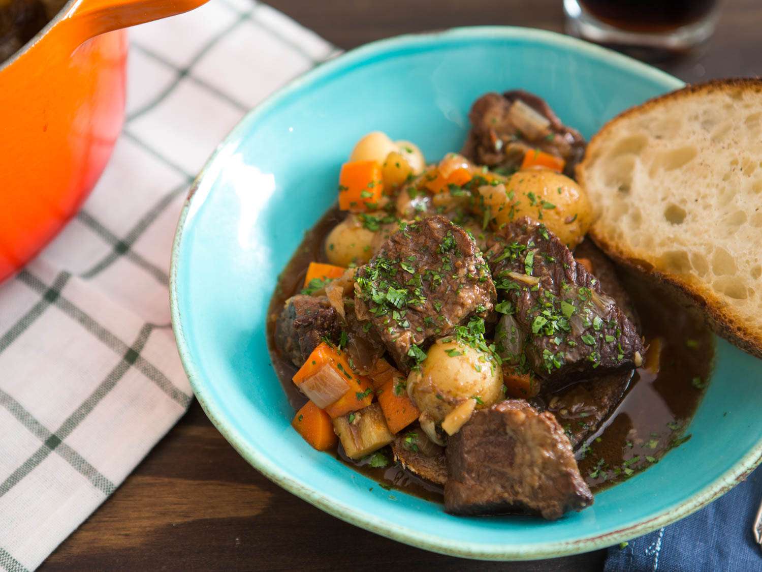Bowl of Irish Guinness Beef Stew garnished with chopped parsley, served with slice of bread