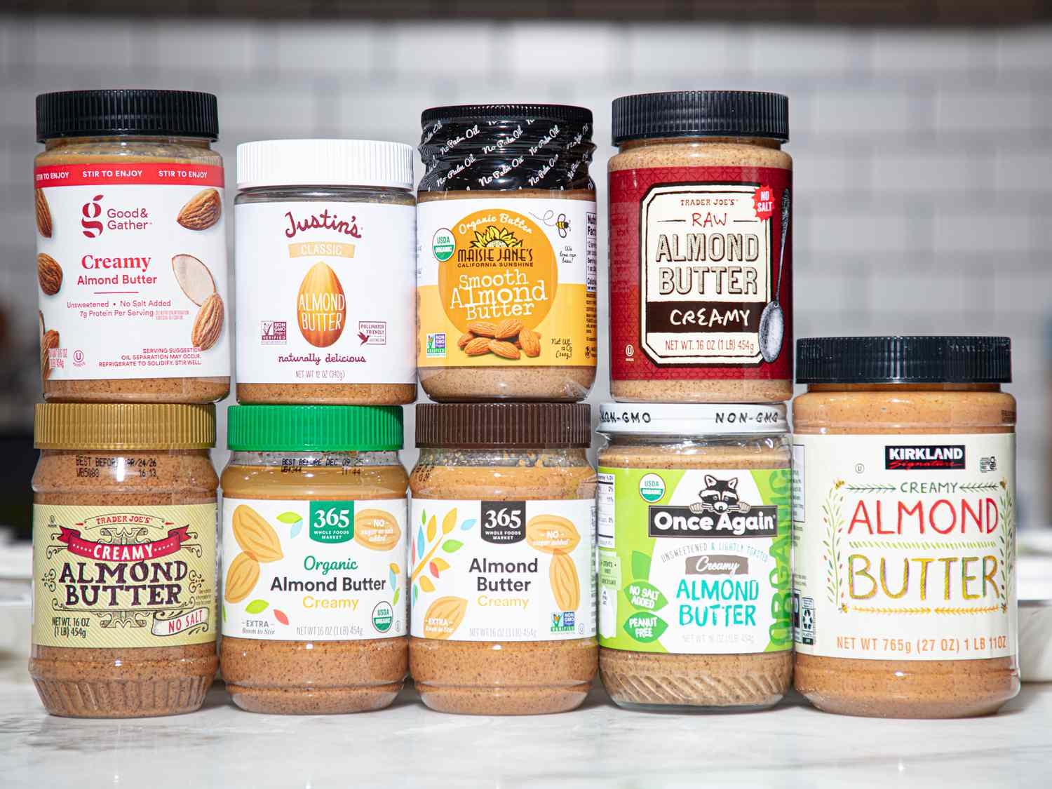 A selection of almond butter jars arranged in rows on a countertop