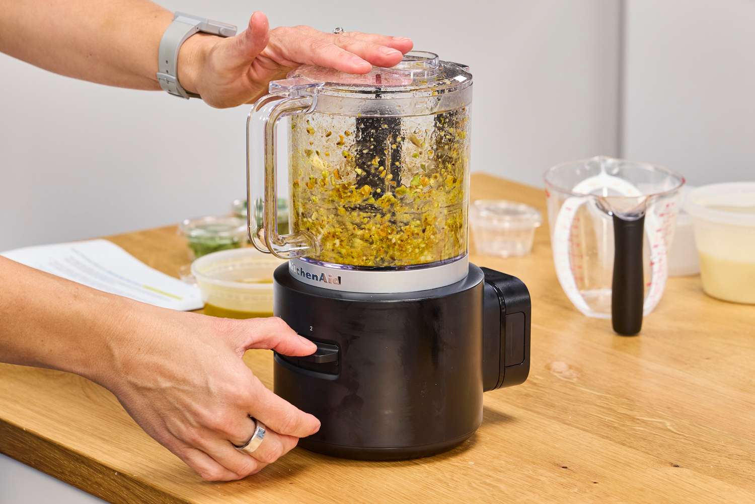 A person chops vegetables in the KitchenAid Go Cordless 5-Cup Food Chopper
