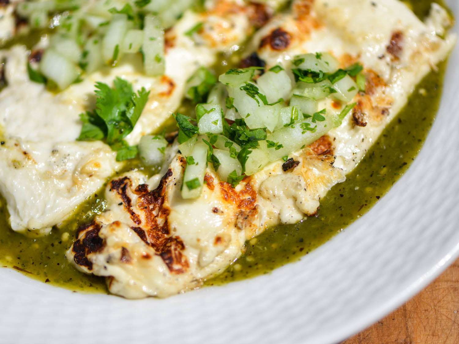 grilled queso panela served over tomatillo poblano salsa, topped with chopped onion and cilantro