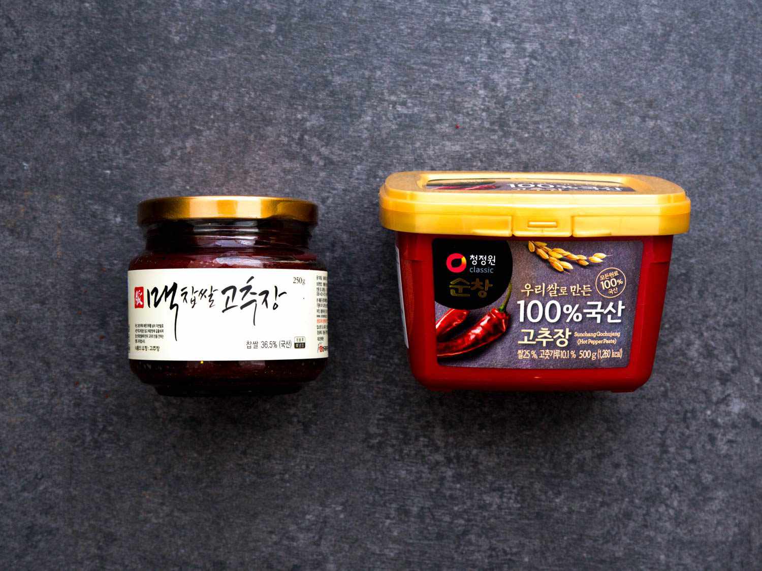 Two varieties of gochujang. One is artisanal, traditionally fermented, and aged. The other is a mass-produced product.