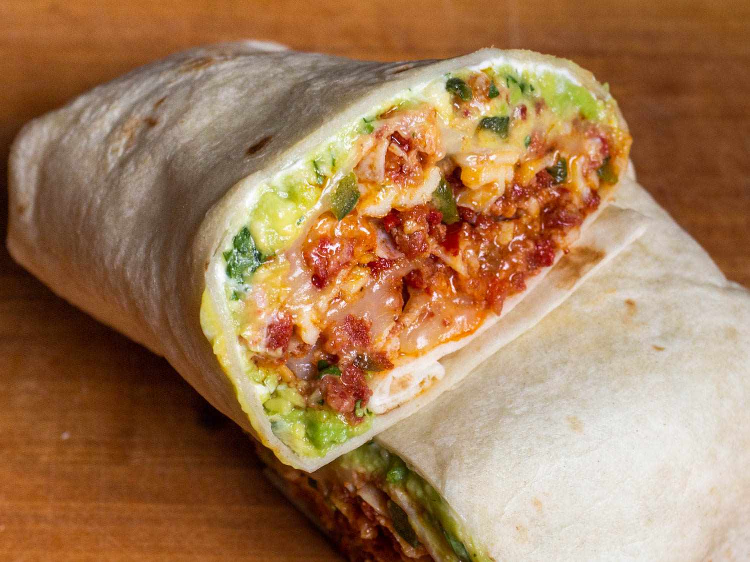 Cross section of a breakfast burrito with chorizo, egg, and refried beans. 