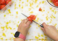 a person slicing a tomato