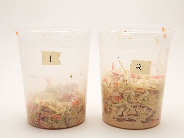 Two numbered deli containers of dressed coleslaw, #1 much denser and more compacted than #2
