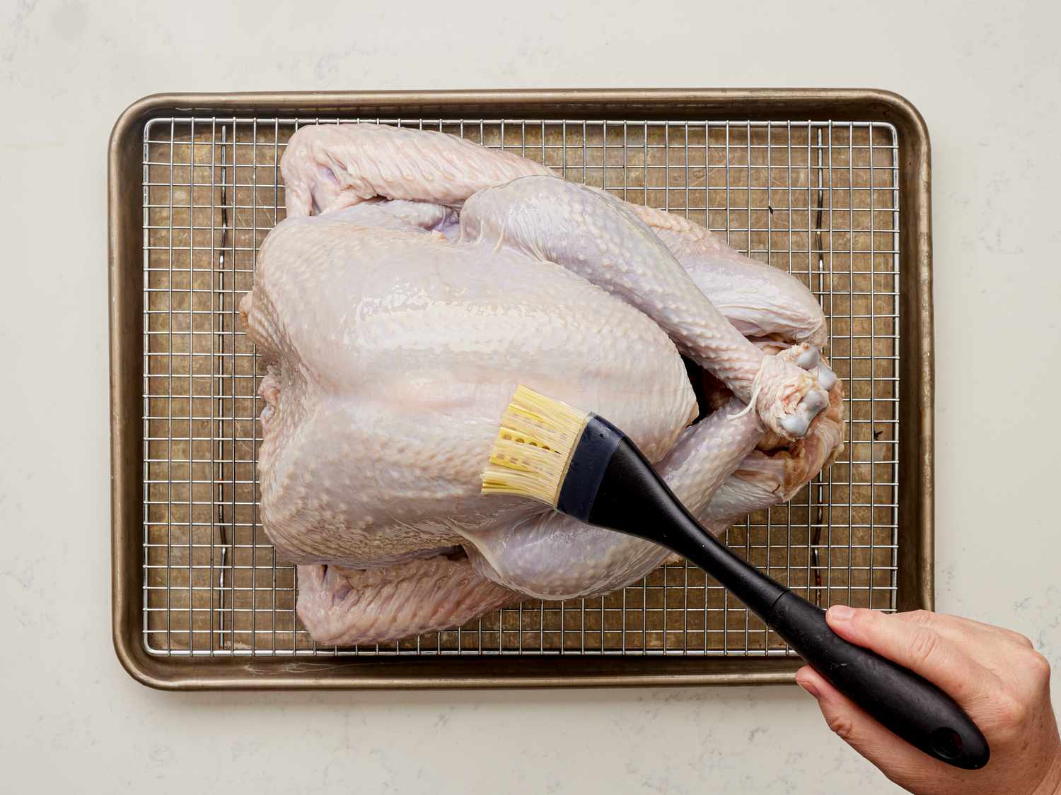 Overhead view of brushing turkey with oil