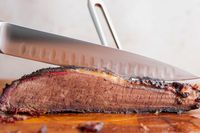 A person slicing meat using the Wusthof Classic Carving Set