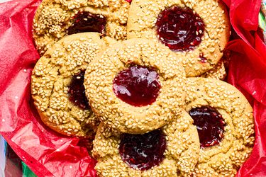 Thumbprint cookies with seeds and jam filling on red wrapping paper