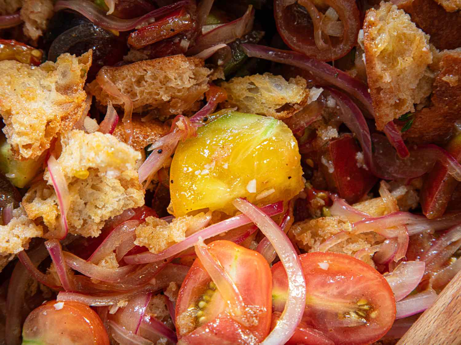 Warm panzanella salad with bread cherry tomatoes onions and other ingredients
