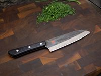 mac superior santoku on a dark wooden cutting board with chopped chives
