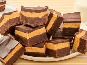 A plate of triplelayer peanut butter brownies with chocolate and peanut butter layers