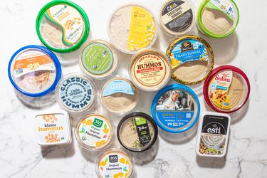 A variety of hummus containers displayed on a white background