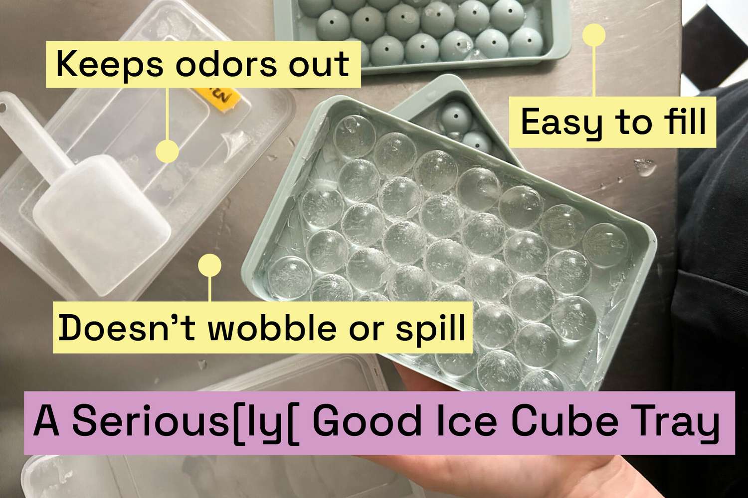 A pale gray ice cube tray filled with spherical cubes.