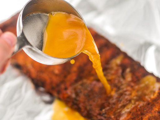 The liquid seasoning is spooned over the ribs.