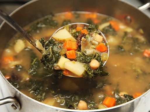 Closeup of hearty winter vegetable soup ladled out of pot