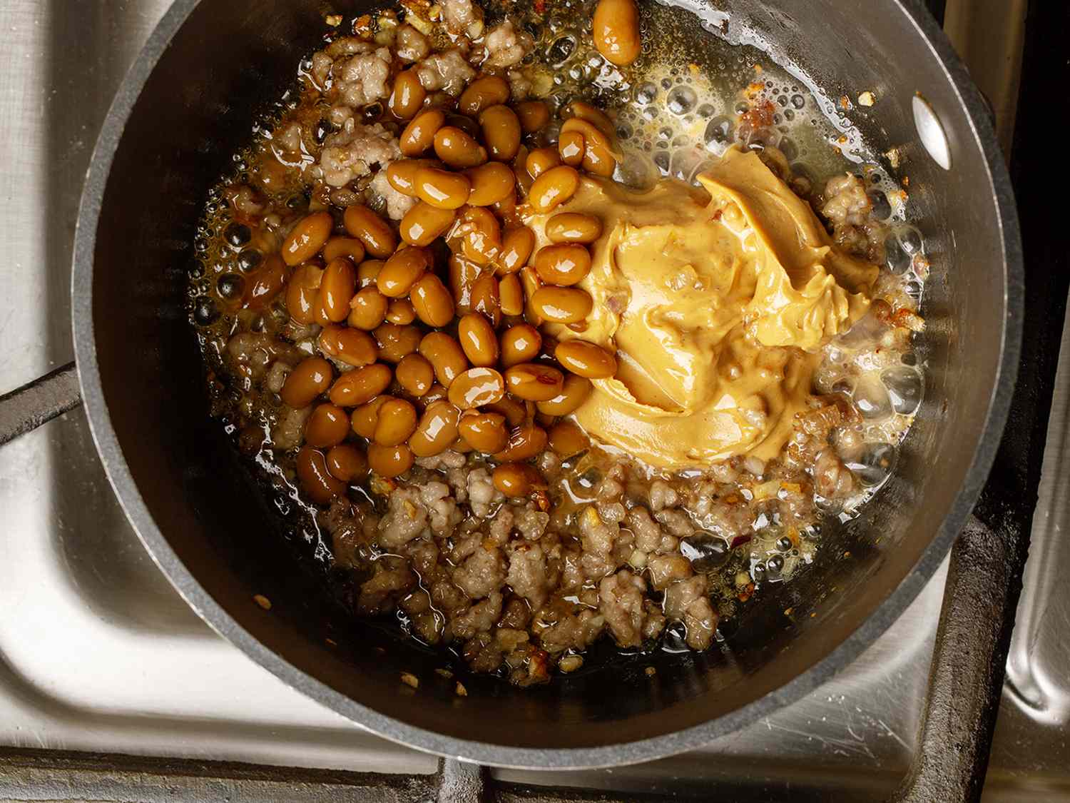 Ground pork, shallots, garlic, whole grain soybean sauce and peanut butter in a saucepan