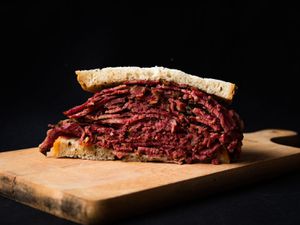 Profile view of a gigantic pastrami sandwich on rye bread.