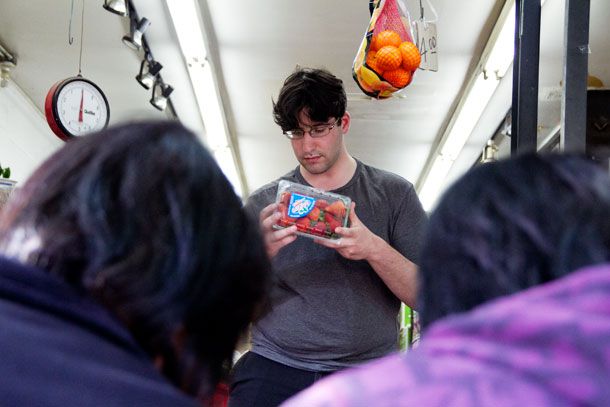 Max Falkowitz holding a container of strawberries.