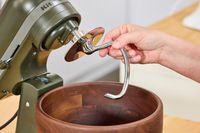 A person attaches the dough hook to the KitchenAid Design Series Evergreen Stand Mixer