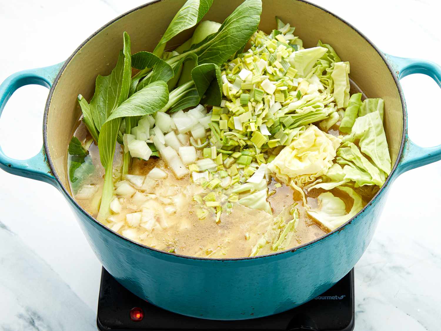 Dutch oven with greens into broth 
