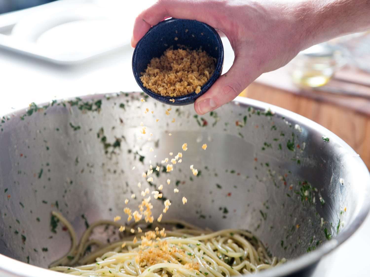 Adding breadcrumbs to the pasta with colatura.