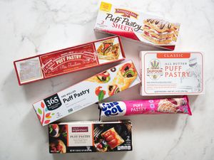 An assortment of puff pastry packaging arranged on a surface representing different brands