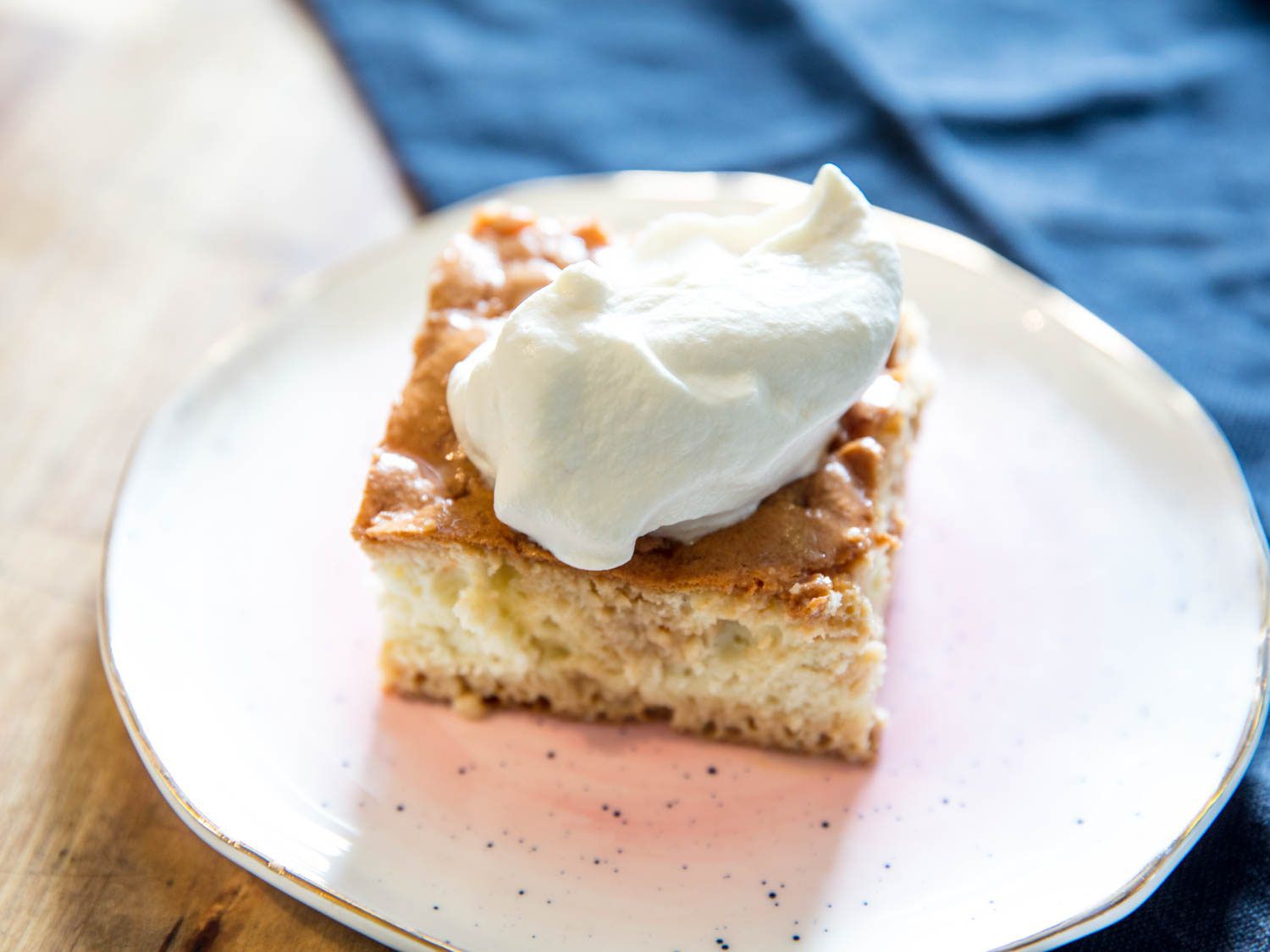 A piece of cake topped with thick whipped cream