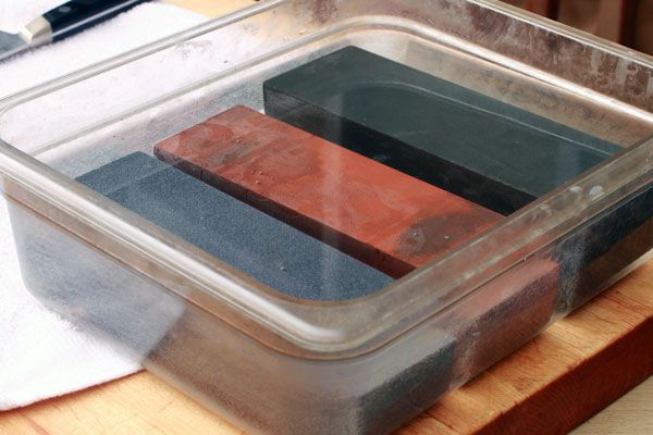 Three wetstones soaking in a tub of water