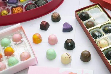 a white tile surface with three different boxed chocolates