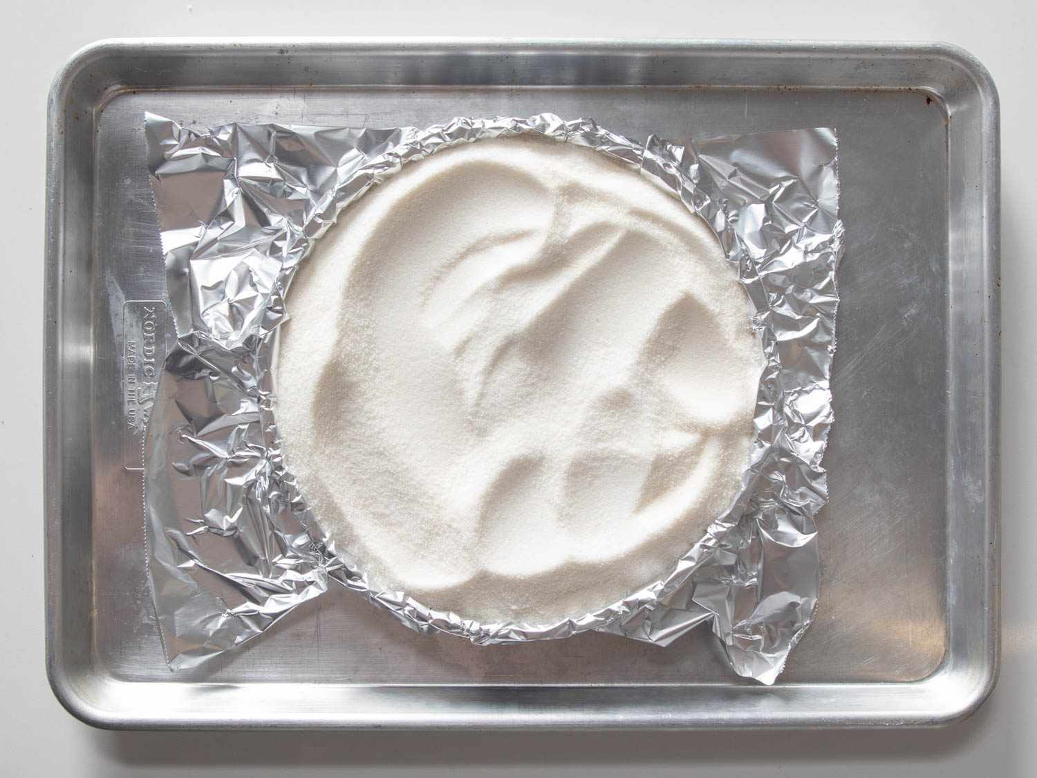 Overhead view of a crust being blind baked. 