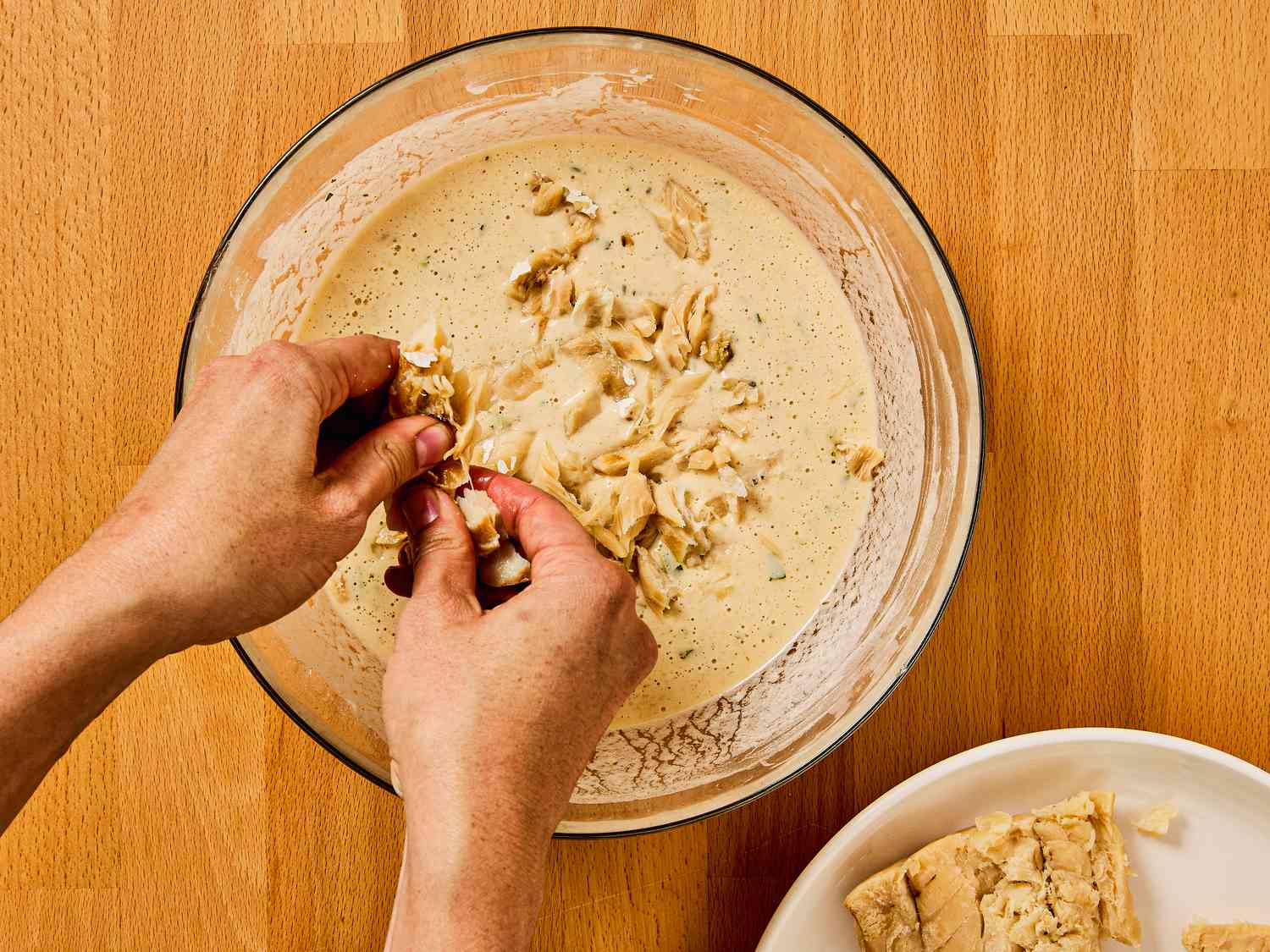 Flaking salted cod into the batter 