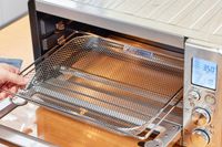 A hand holding the rack from the Breville the Smart Oven Air Fryer